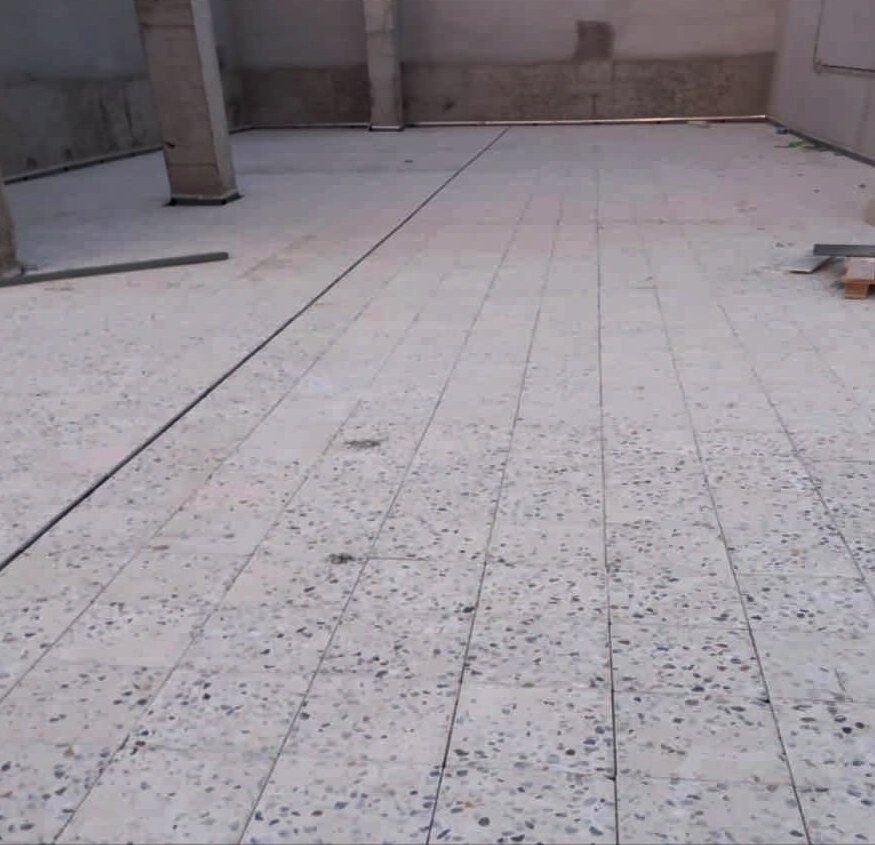 Terrazzo floor — laid, ground and grouted.